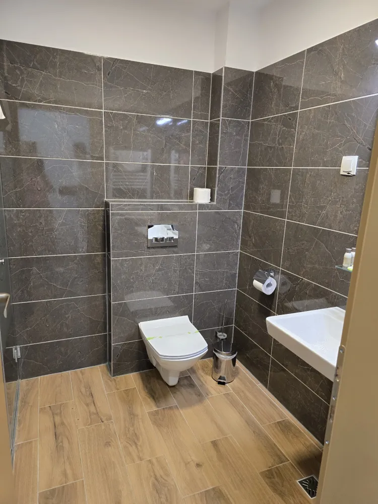 Eigenes Bad mit braunen Fliesen, WC und Waschbecken